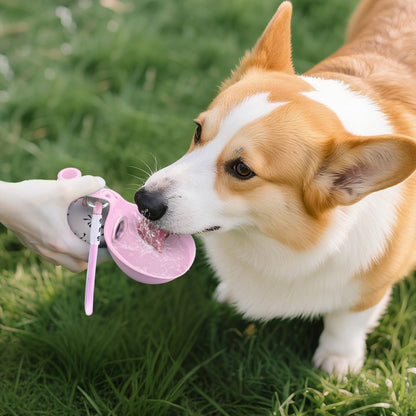 Dog drinking from the fold-out silicone bowl of a pink HydroGo travel water bottle outdoors; usage demonstration.